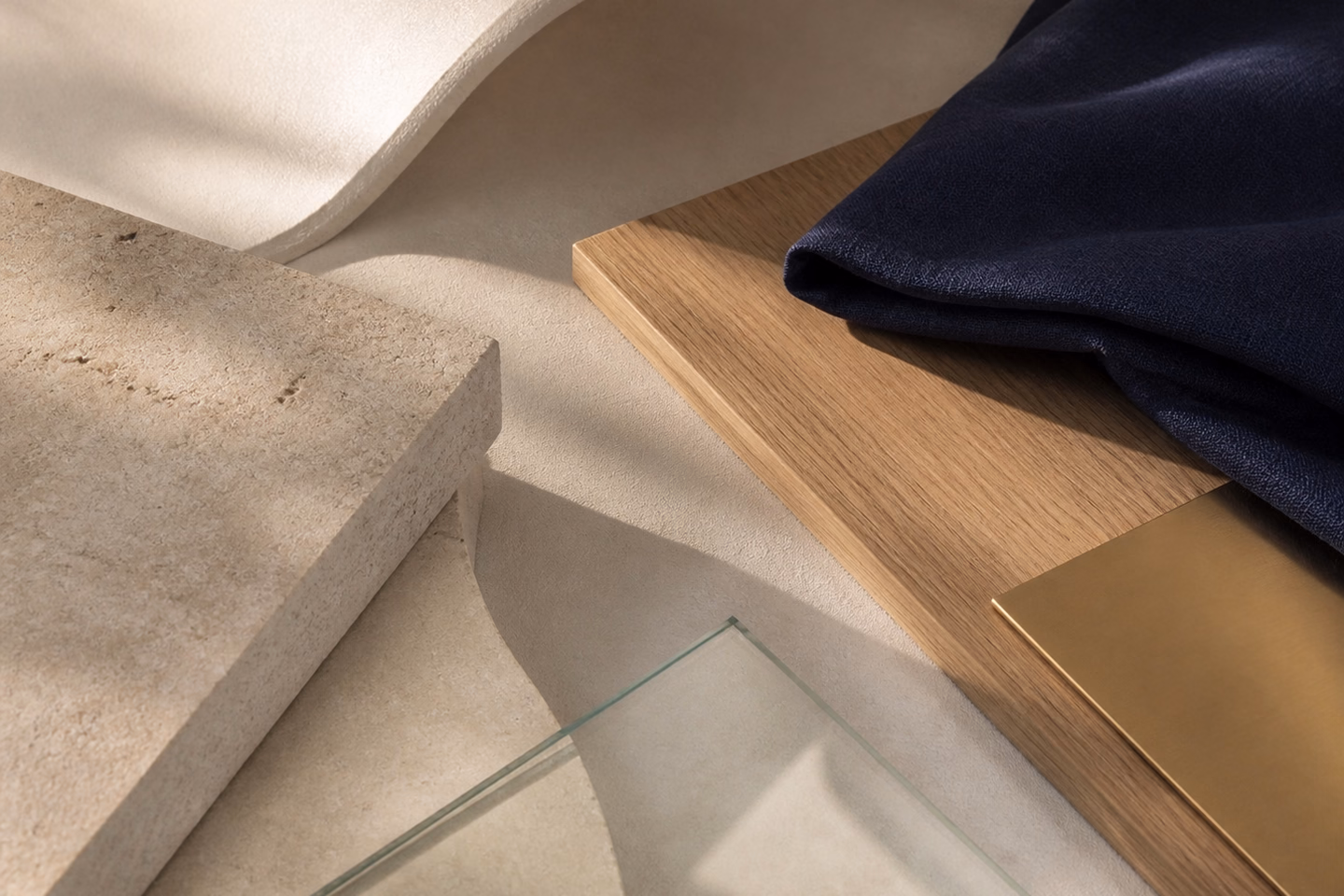 Abstract editorial composition of ivory stone, natural wood, navy textile and champagne-toned metal.